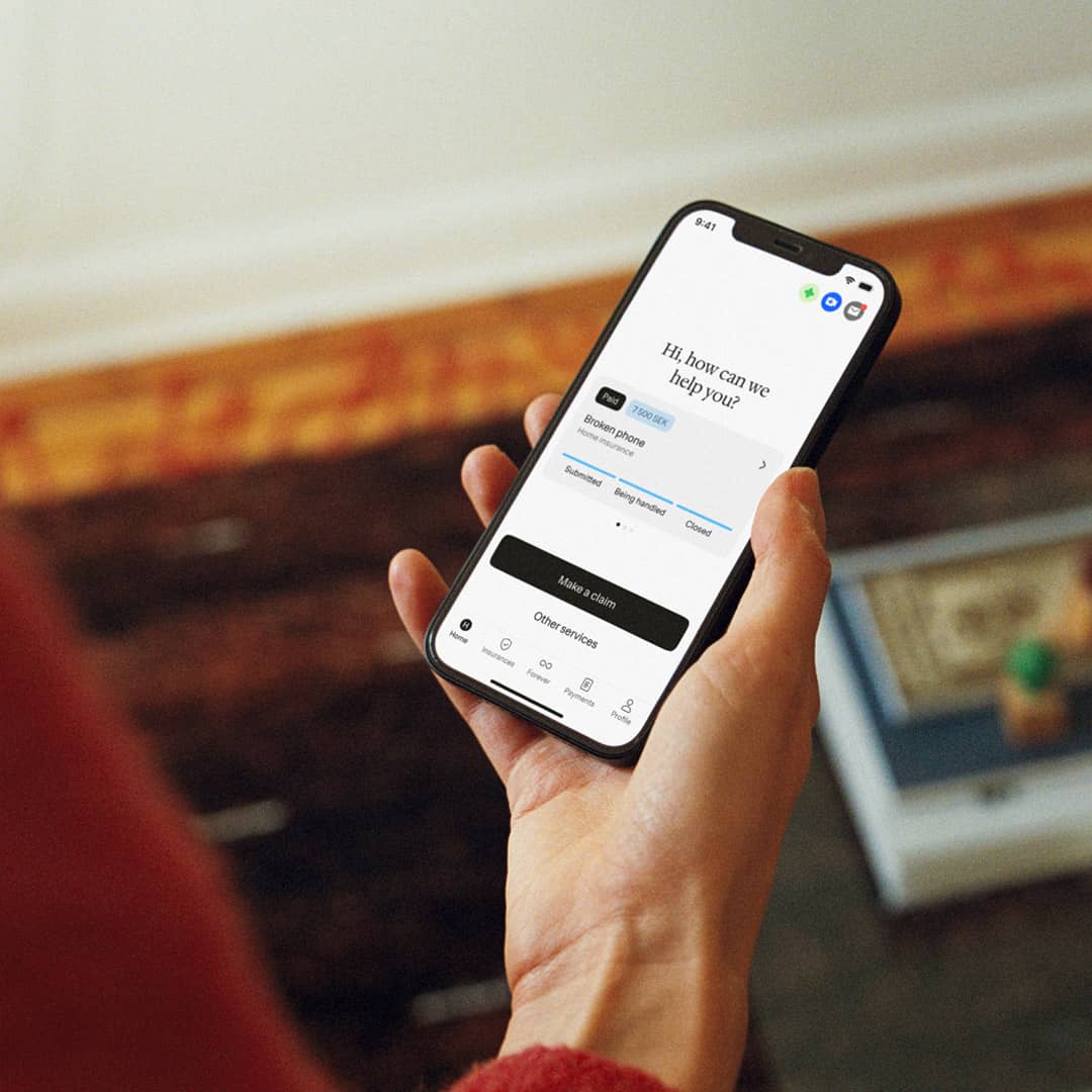 Hand holding mobile with Hedvig app