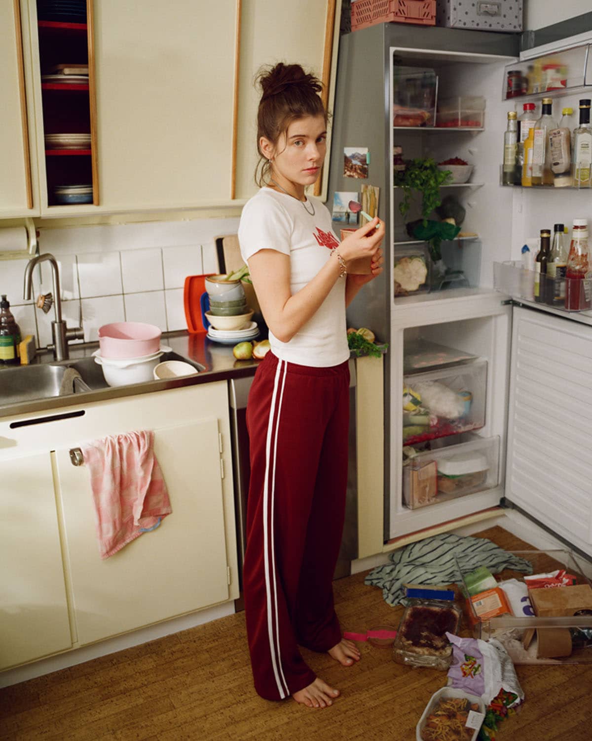 En kvinna står och äter glass i köket