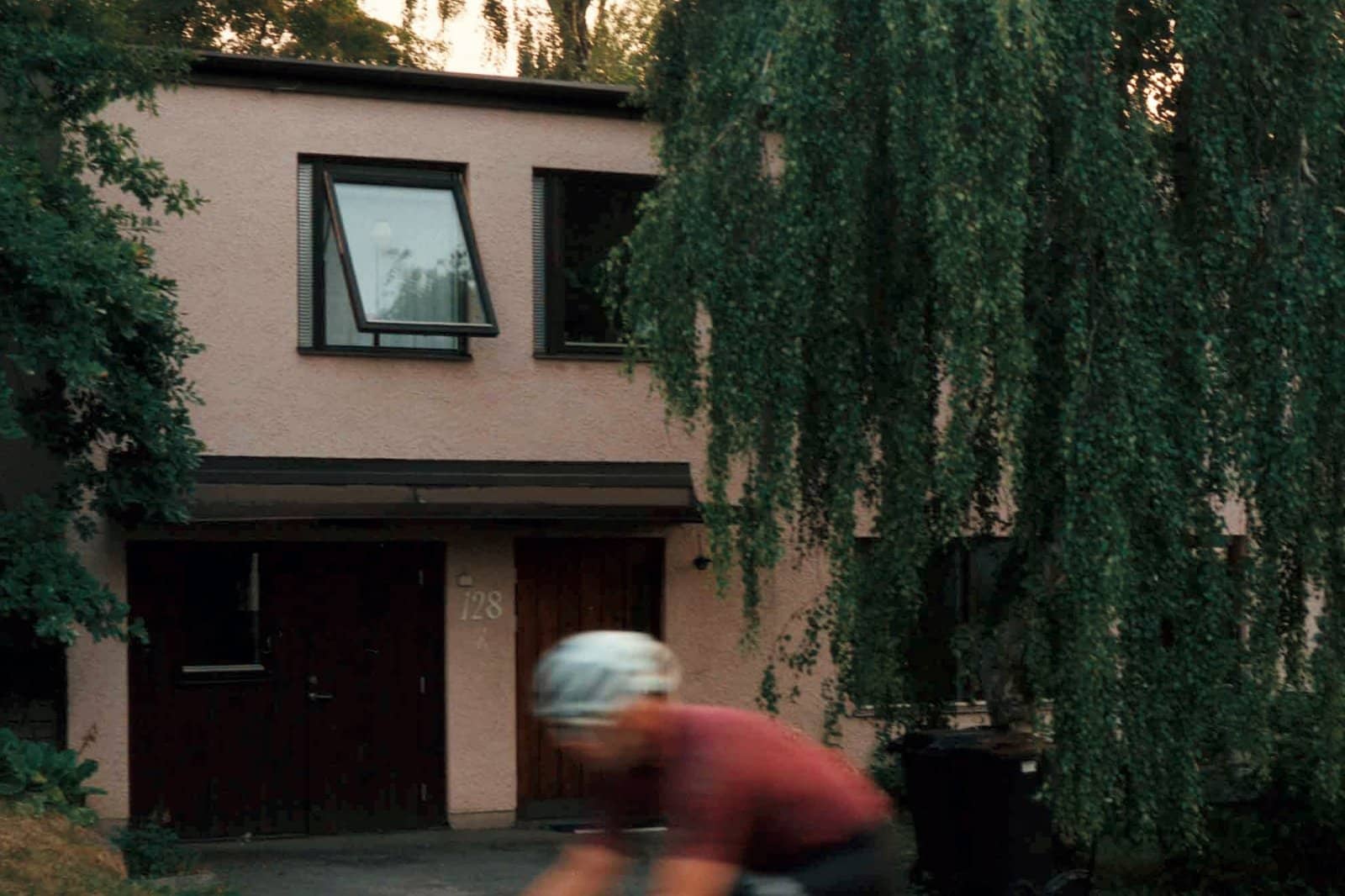 Street view på en villa med cyklist i förgrunden