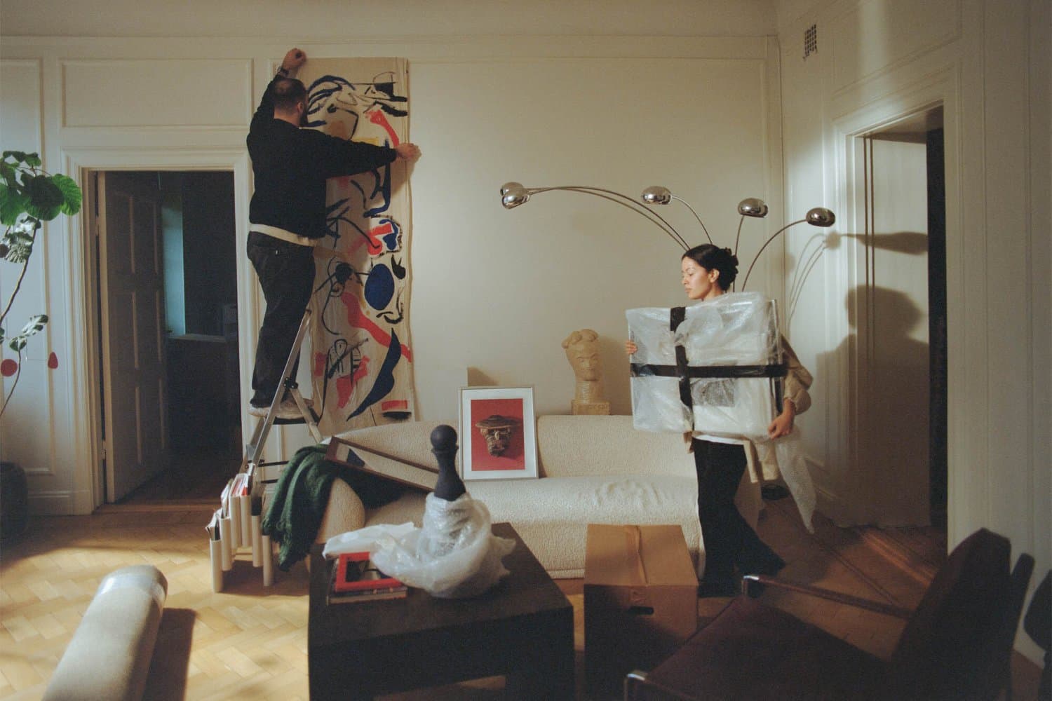 En kvinna och en man flyttar in möbler i en lägenhet