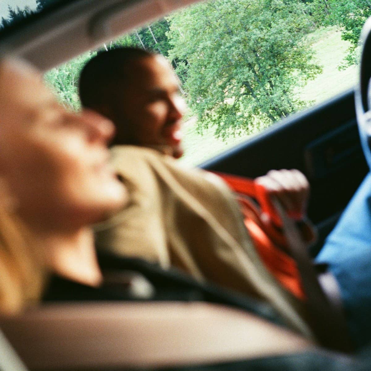 Två suddiga personer som sätter sig i en bil