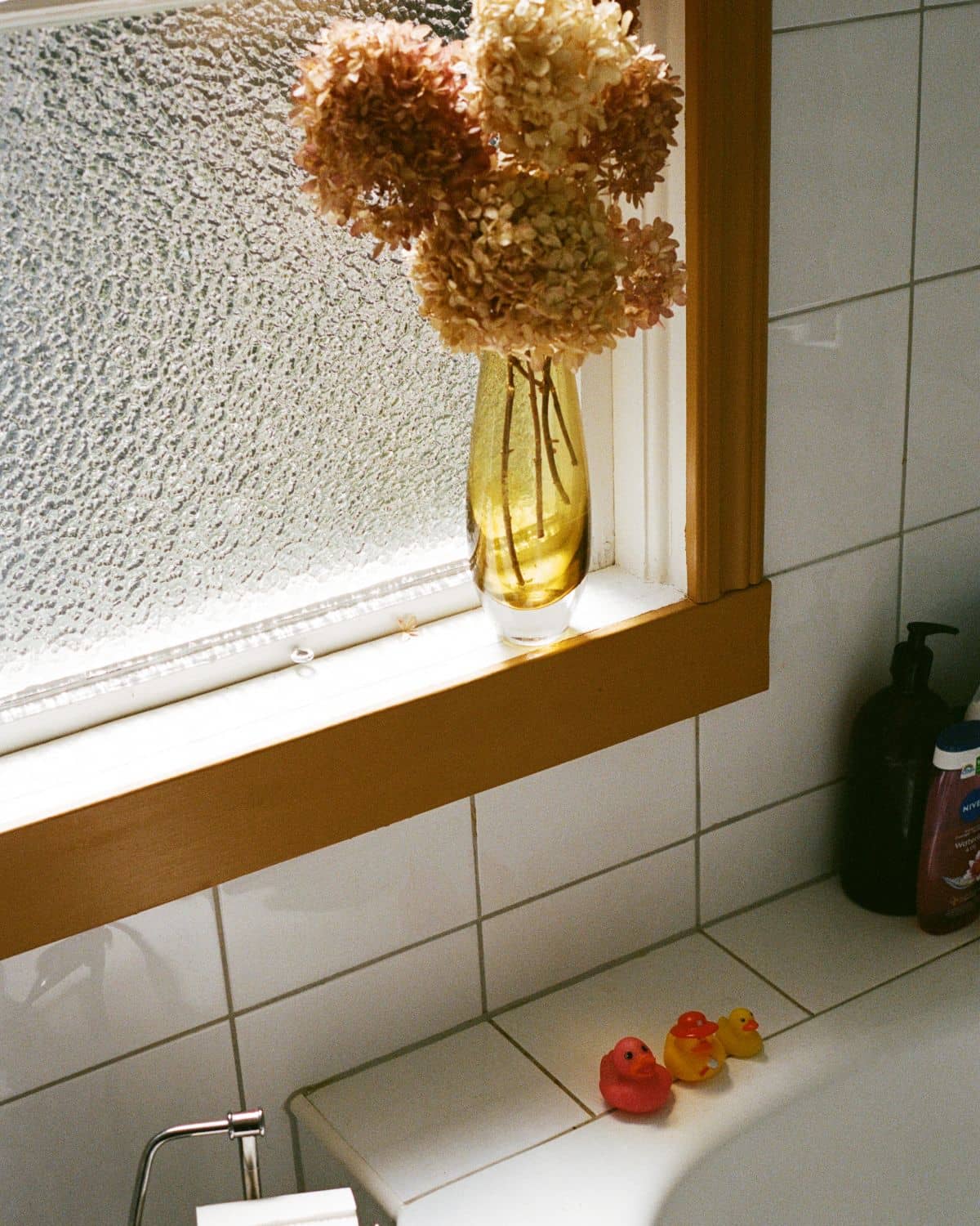 Badrum med torkade blommor i fönstret