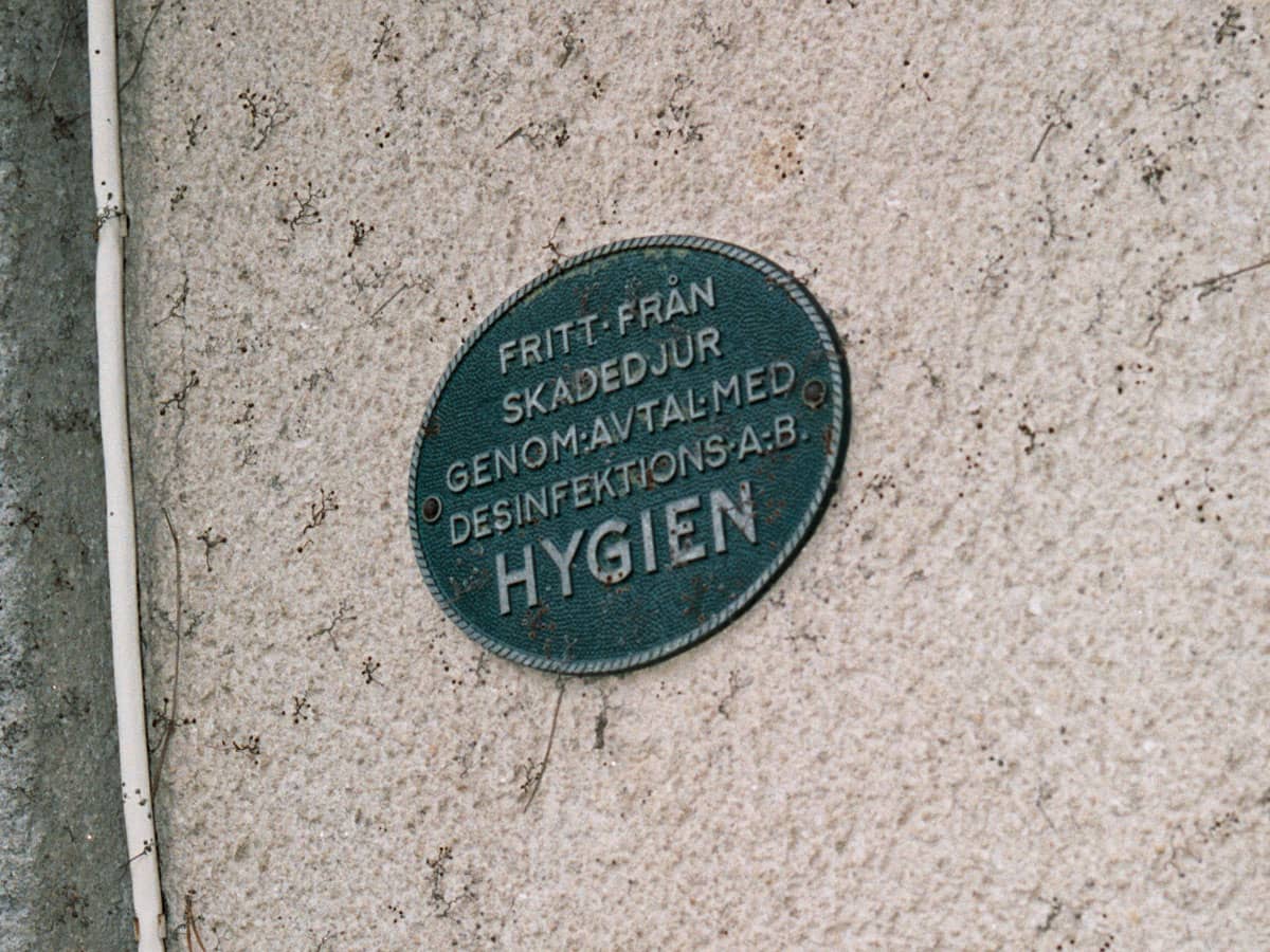 Gammal skylt om bekämpning av skadedjur på fasad