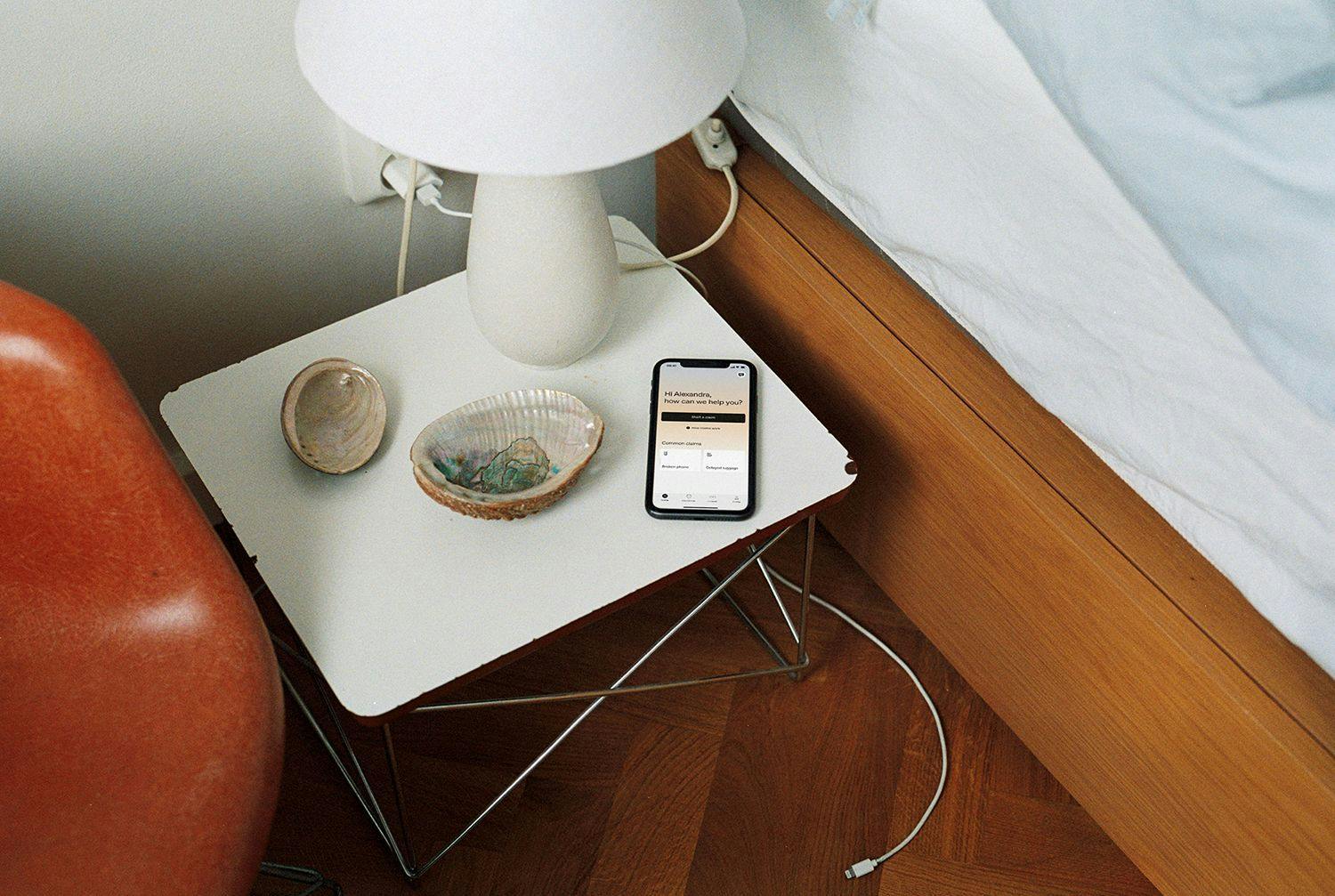 Iphone med Hedvig app liggandes på sovrumsbordet.
