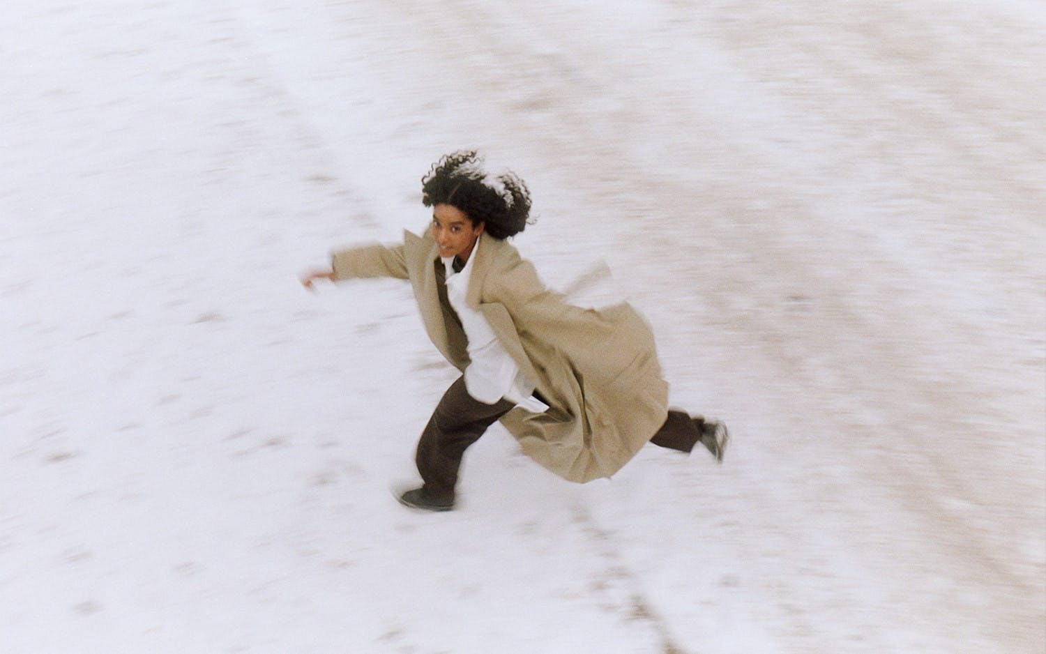 Woman with accident insurance walks across a snow-covered field.