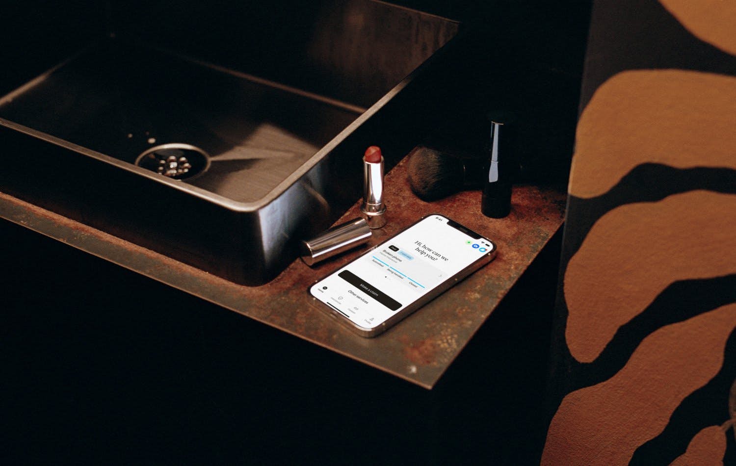 Phone by the bathroom sink next to a lipstick.