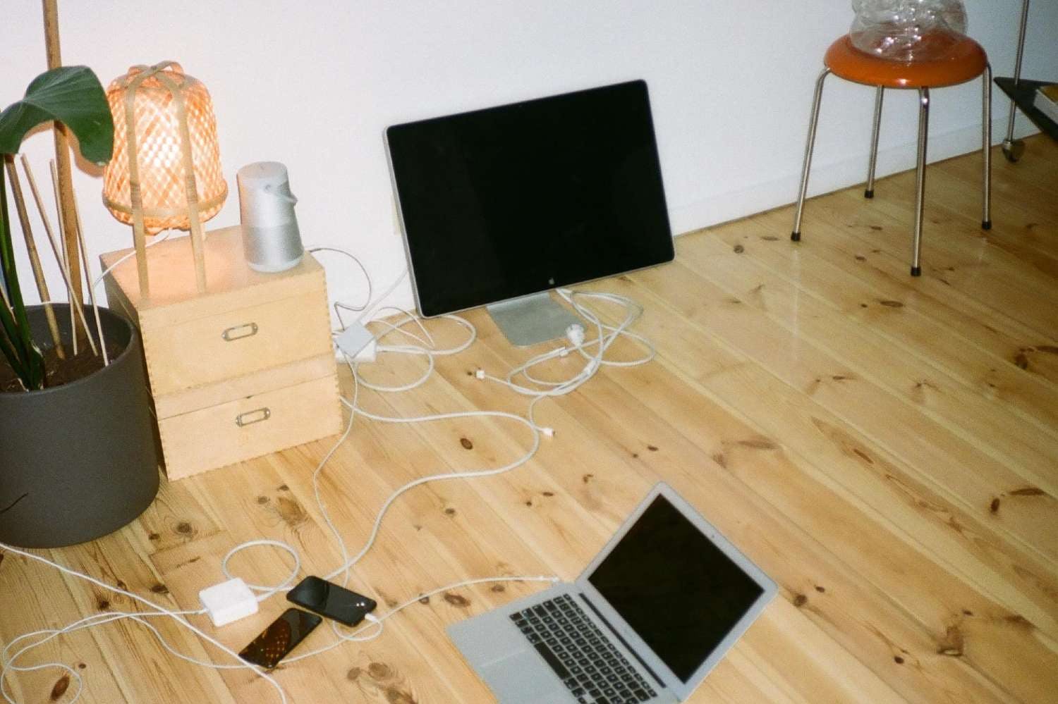Laptop och andra saker på golvet i en studentlägenhet.