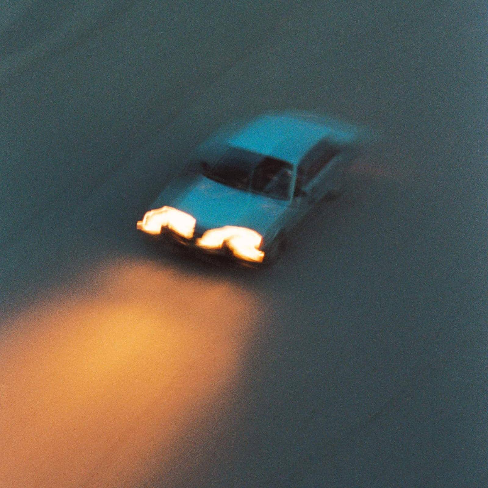 Bil kör i mörker med framljus tända