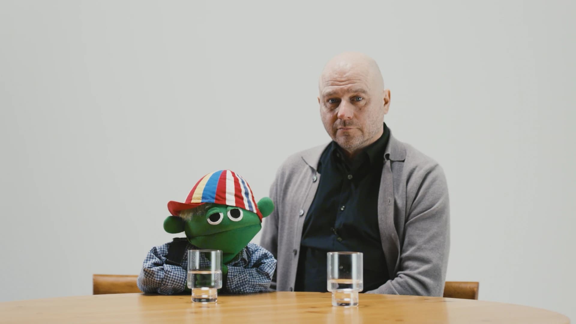 Skurt och försäkringsexperten Tobbe sitter vid ett bord