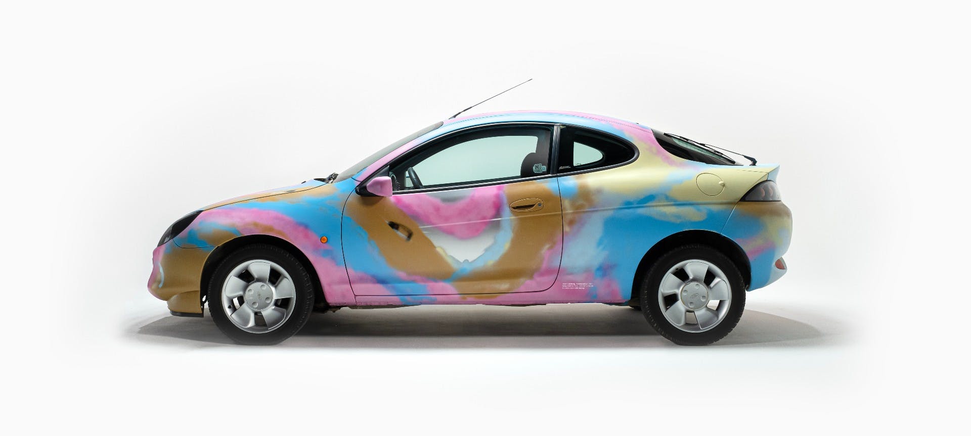 En spraymålad sommarbil i glada färger.