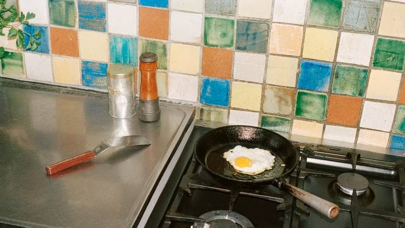 Steker ägg i stekpanna på spis.