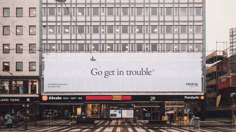 Banderoll på hus med kampanjen "Go get in trouble".